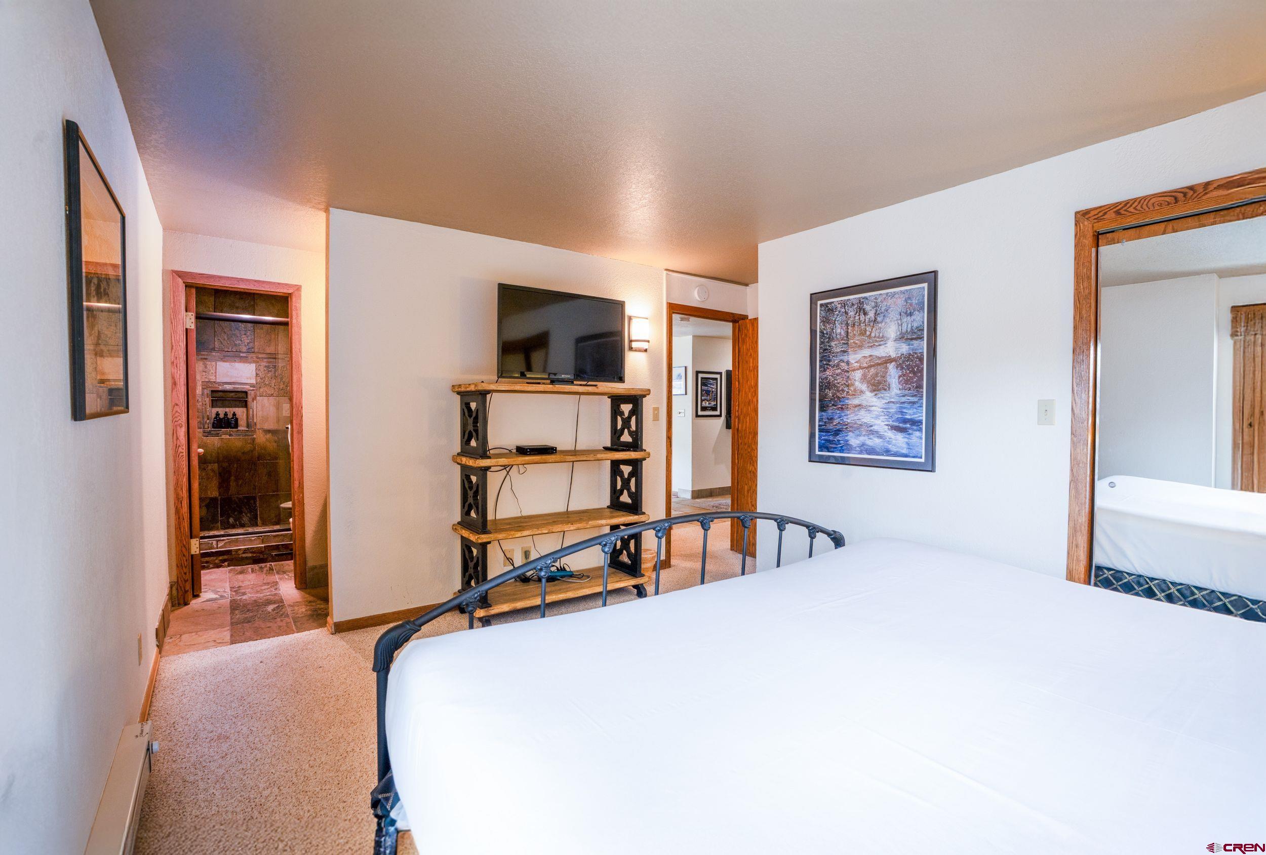 11 Snowmass Road, Unit 440 Crested Butte, CO 81225 - Photo 18 of 41 a bedroom with a bed and a flat screen tv