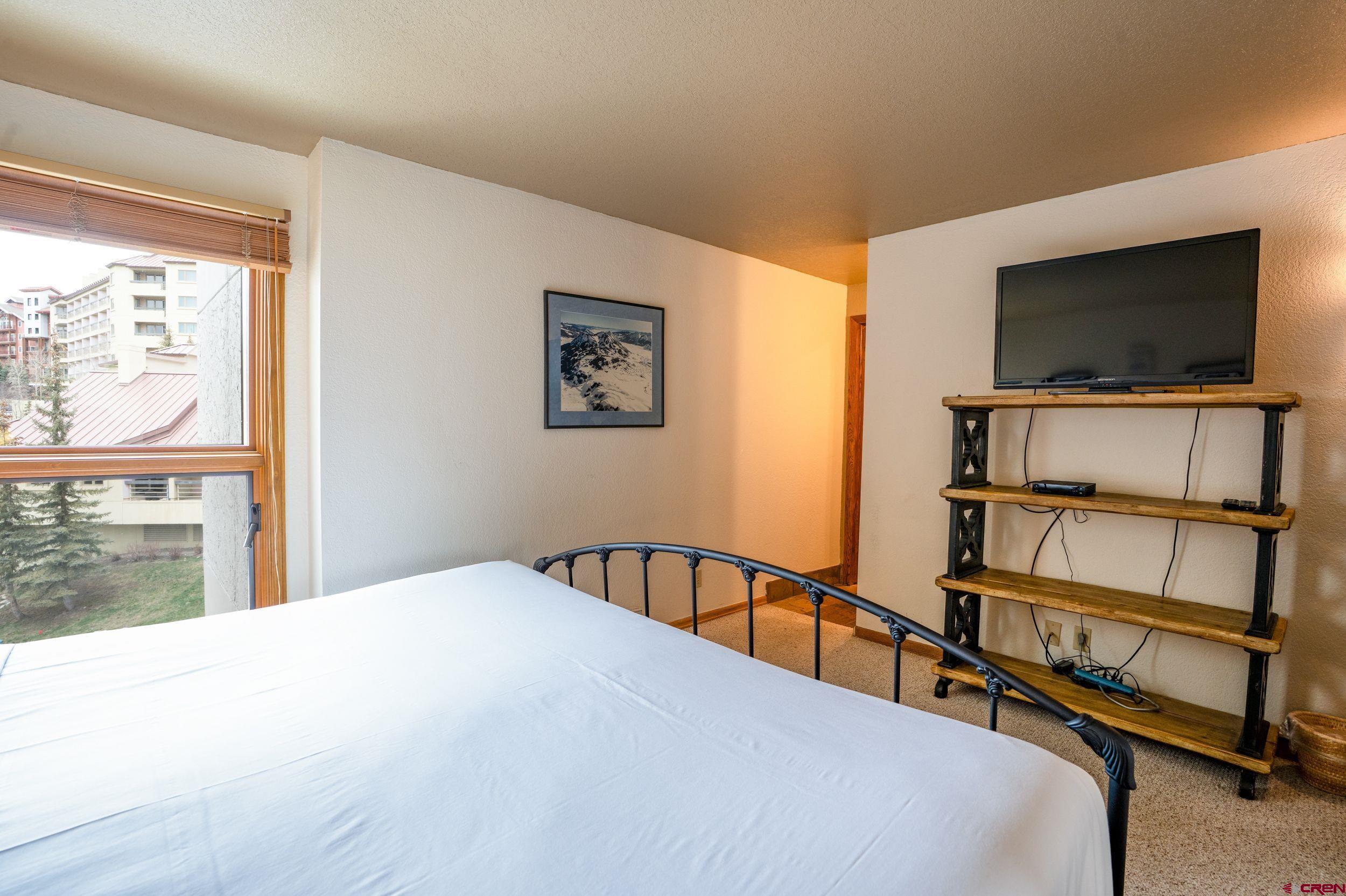 11 Snowmass Road, Unit 440 Crested Butte, CO 81225 - Photo 19 of 41 a bedroom with furniture and a flat screen tv