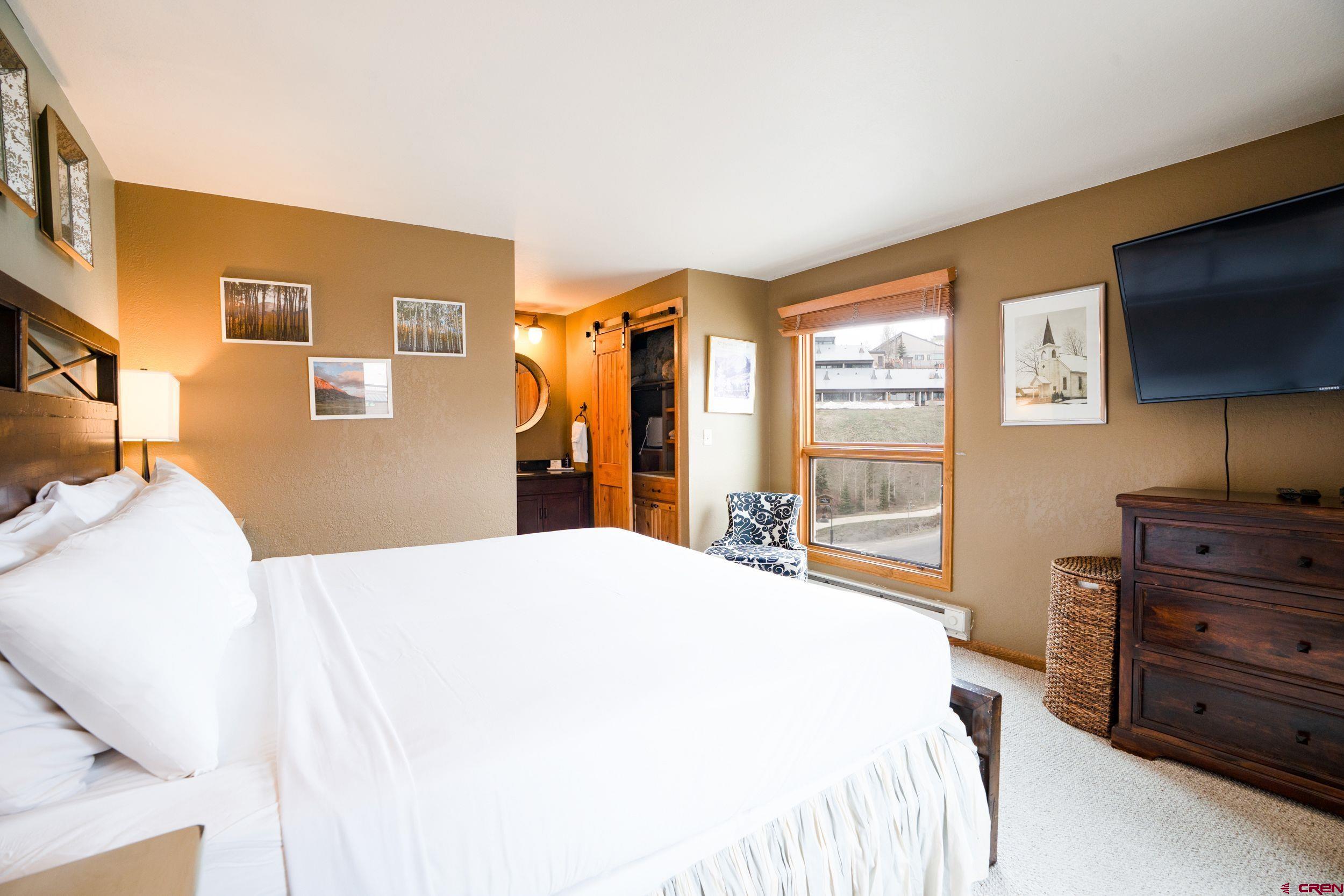 11 Snowmass Road, Unit 440 Crested Butte, CO 81225 - Photo 20 of 41 a bedroom with a bed and a flat screen tv
