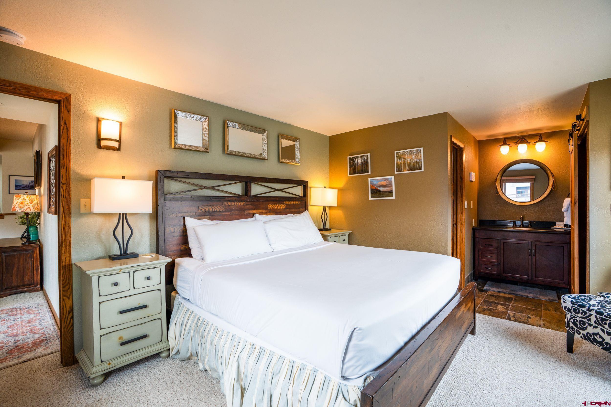 11 Snowmass Road, Unit 440 Crested Butte, CO 81225 - Photo 21 of 41 a bedroom with a bed and a lamp