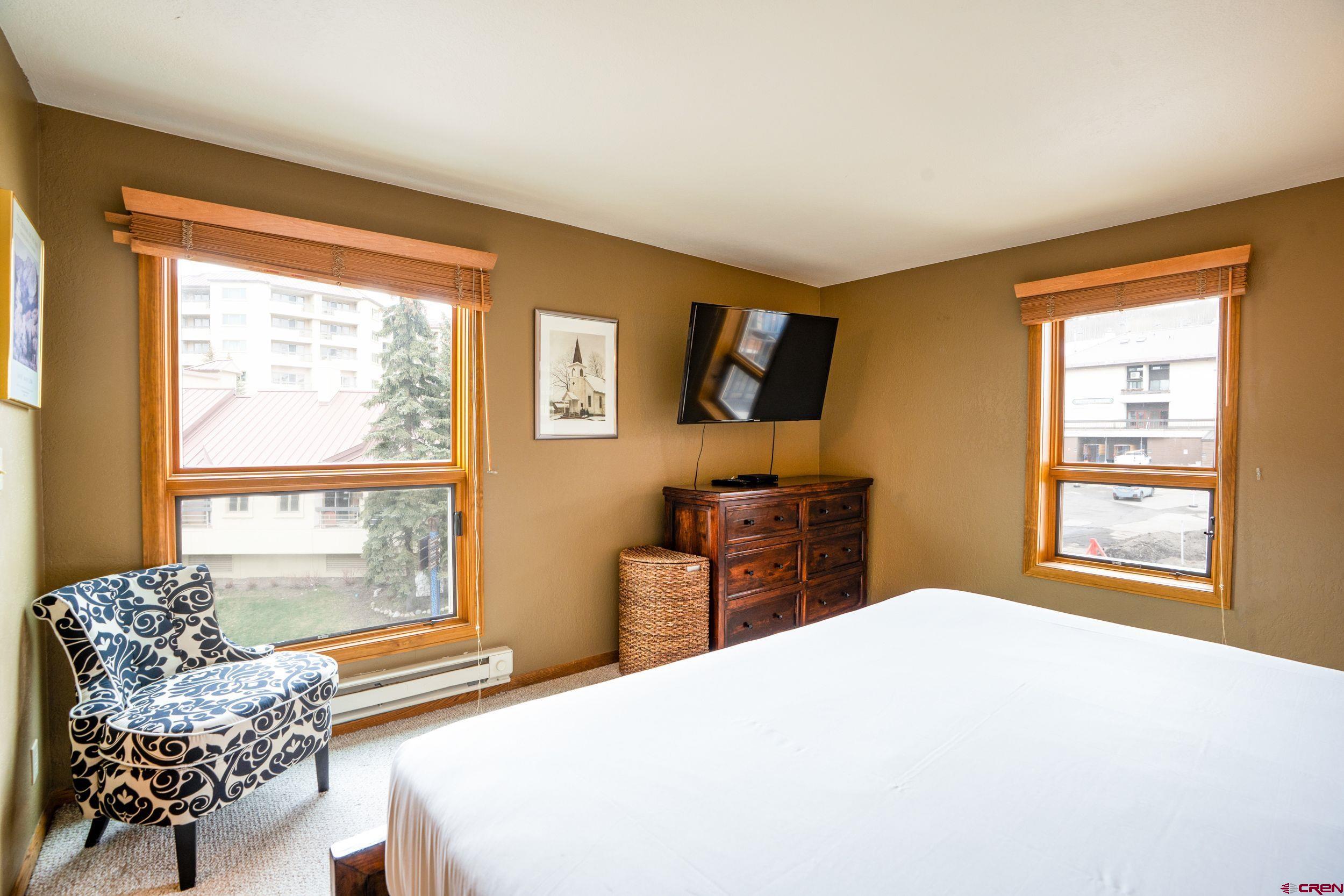 11 Snowmass Road, Unit 440 Crested Butte, CO 81225 - Photo 23 of 41 a bedroom with a bed and a television