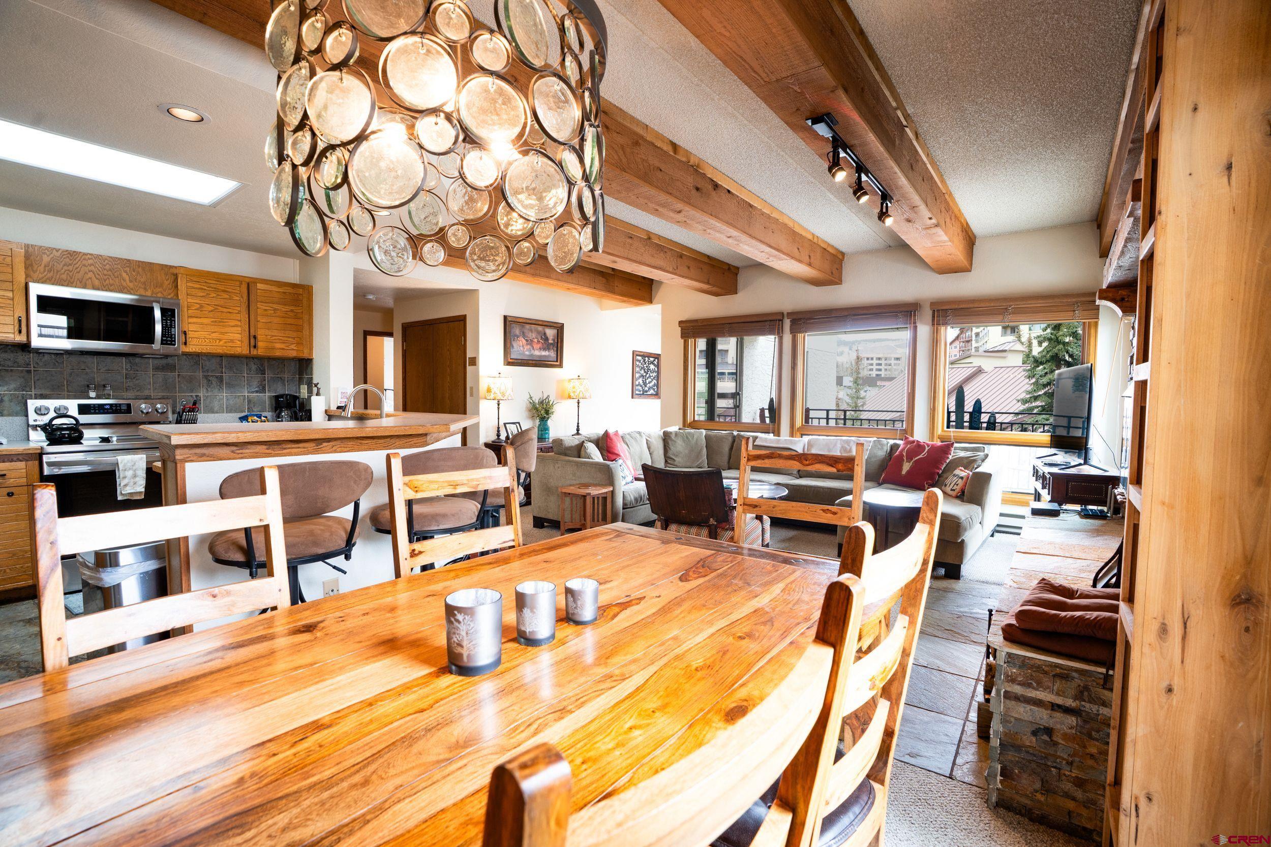 11 Snowmass Road, Unit 440 Crested Butte, CO 81225 - Photo 6 of 41 a living room with furniture a flat screen tv and a dining table