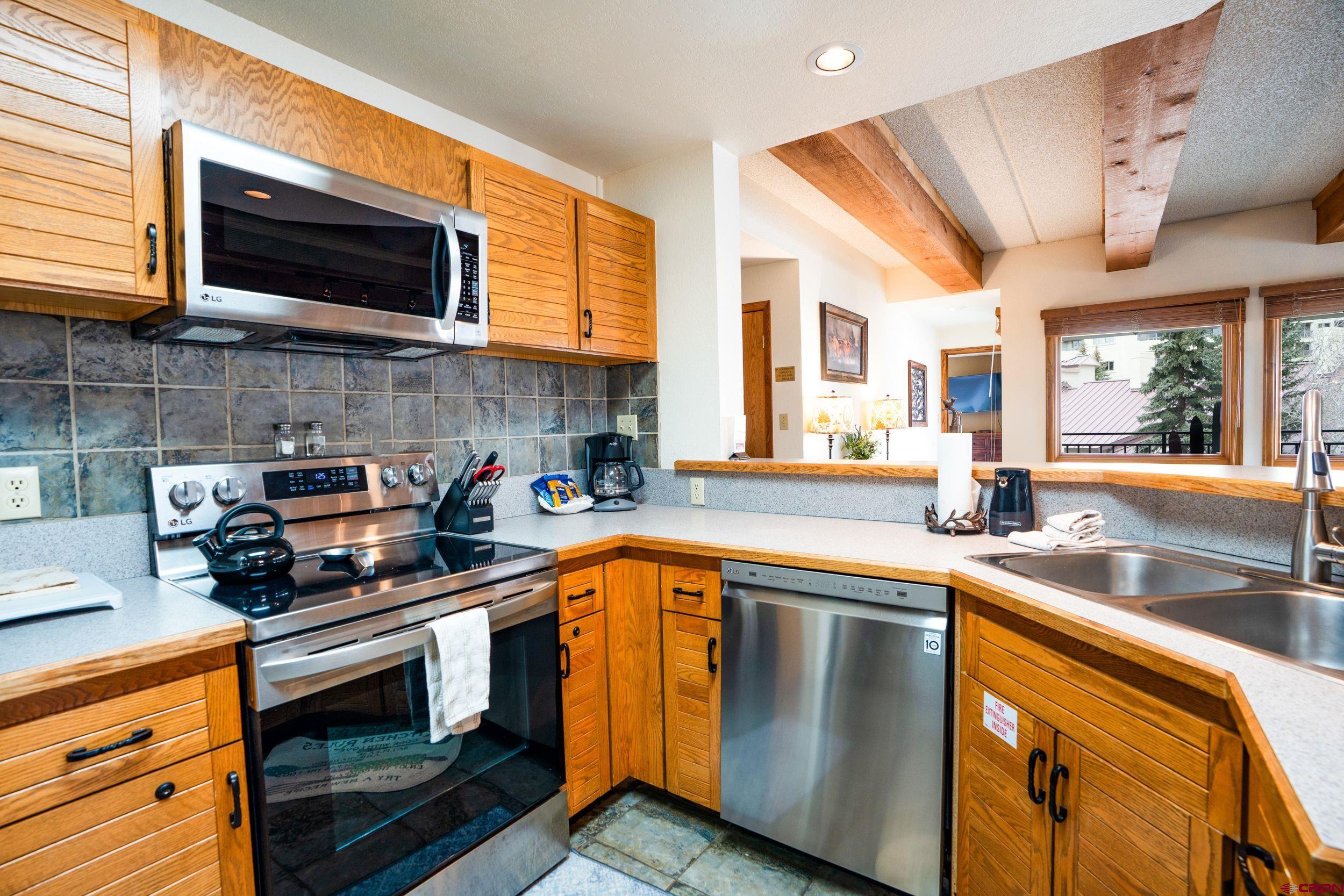 11 Snowmass Road, Unit 440 Crested Butte, CO 81225 - Photo 7 of 41 a kitchen with stainless steel appliances granite countertop a stove a sink and a microwave