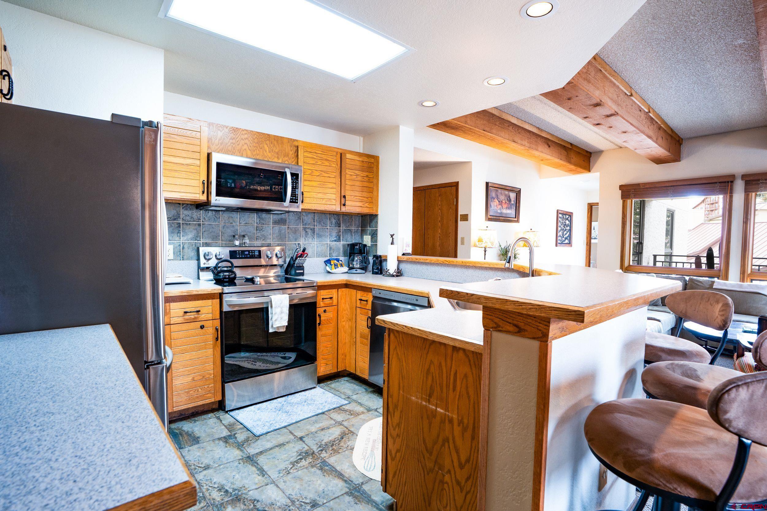 11 Snowmass Road, Unit 440 Crested Butte, CO 81225 - Photo 9 of 41 a kitchen with stainless steel appliances granite countertop a sink a stove and a refrigerator