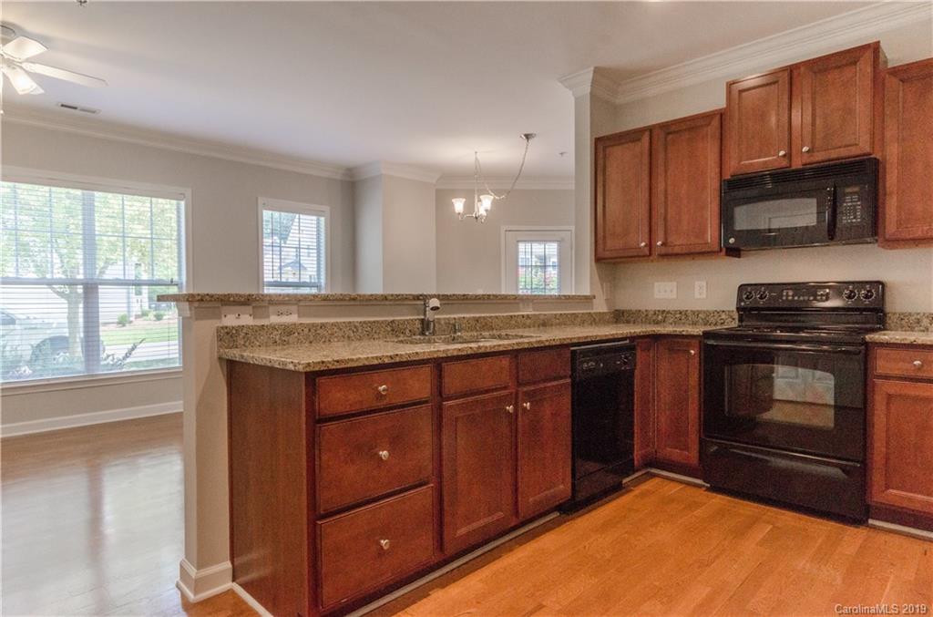4154 Walker Road Charlotte, NC 28211 - Photo 14 of 37 a kitchen with granite countertop wooden cabinets stainless steel appliances and a window