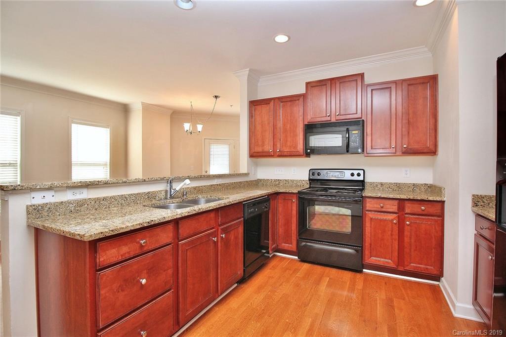 4154 Walker Road Charlotte, NC 28211 - Photo 16 of 37 a kitchen with stainless steel appliances granite countertop wooden cabinets a stove a sink and a wooden floor