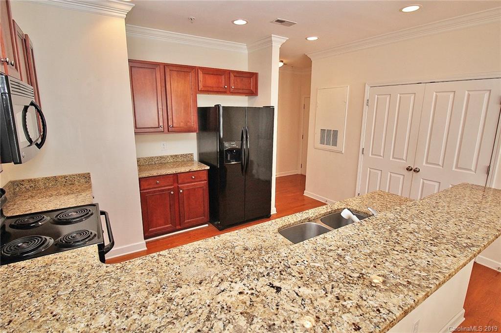 4154 Walker Road Charlotte, NC 28211 - Photo 20 of 37 a kitchen with stainless steel appliances kitchen island granite countertop a refrigerator and a stove top oven