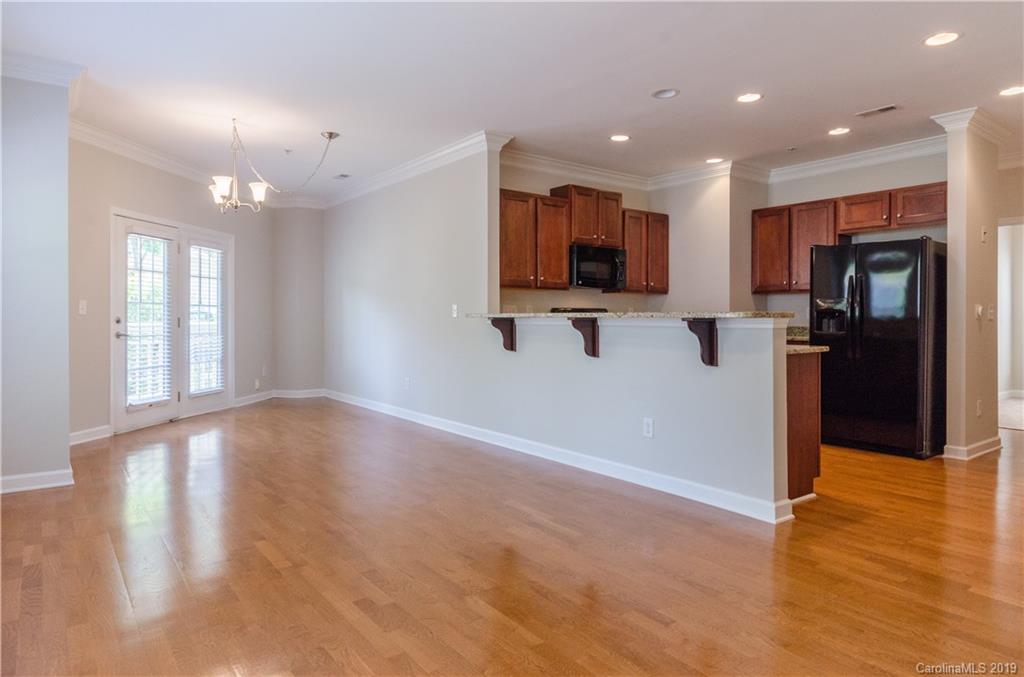 4154 Walker Road Charlotte, NC 28211 - Photo 22 of 37 a view of empty room with wooden floor and a kitchen