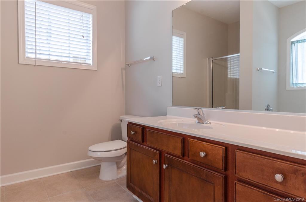 4154 Walker Road Charlotte, NC 28211 - Photo 34 of 37 a bathroom with a granite countertop sink toilet a large mirror and a window