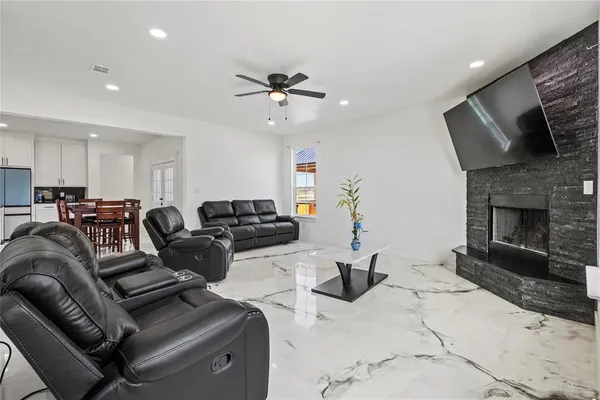 a living room with furniture ceiling fan and a fireplace