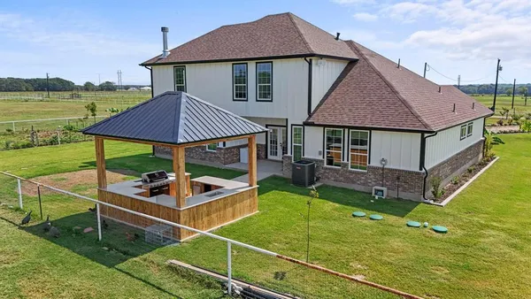 a view of a house with backyard and sitting area