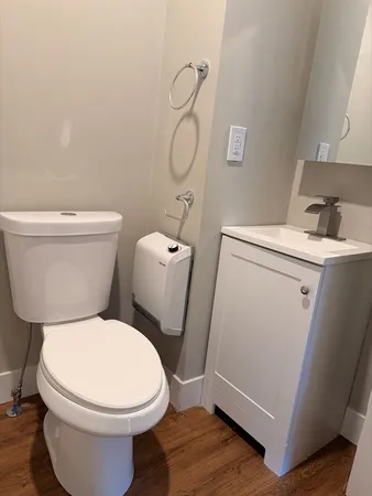 a white toilet sitting next to a bathroom sink and vanity