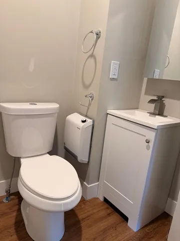 a white toilet sitting next to a bathroom sink and vanity