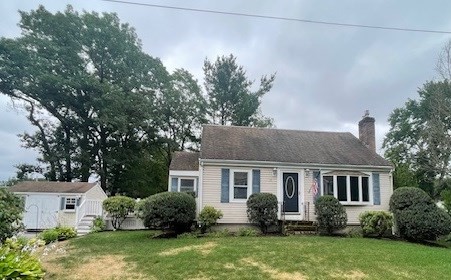 a front view of a house with a yard and trees