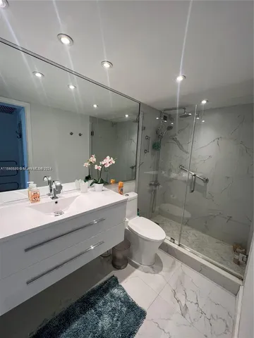 a bathroom with a double vanity sink toilet and shower