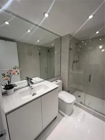 a bathroom with a double vanity sink toilet and shower
