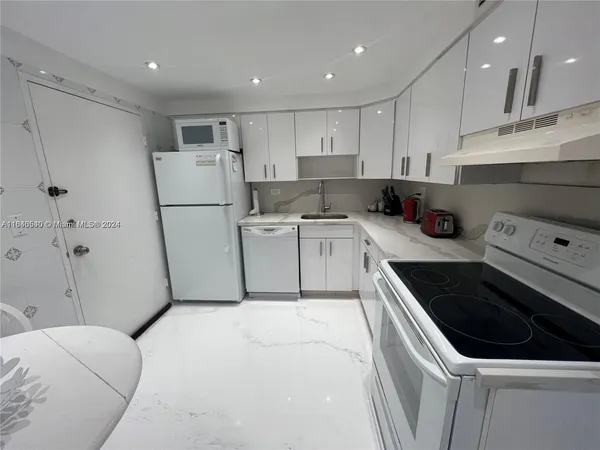 a kitchen with a sink a refrigerator and cabinets
