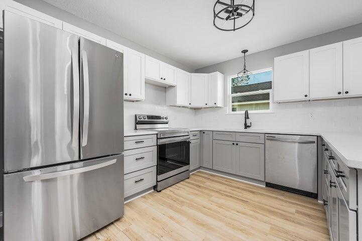5428 Bayleaf Drive Crestview, FL 32539 - Photo 8 of 23 a kitchen with cabinets stainless steel appliances and wooden floor