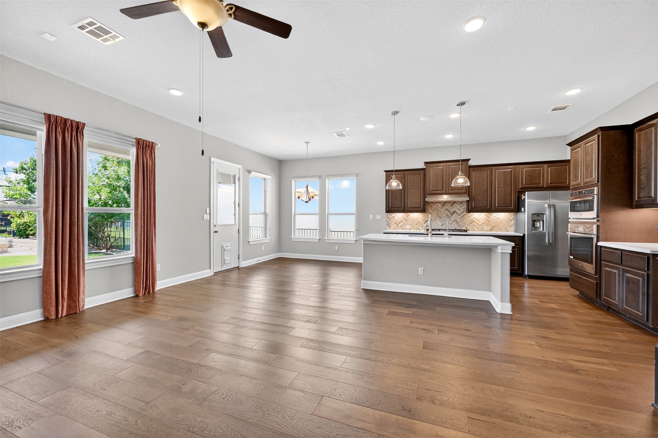 1201 Positano Pass Leander, TX 78641 - Photo 21 of 40 Open-concept living space featuring wood-finish flooring, recessed lighting, and multiple windows