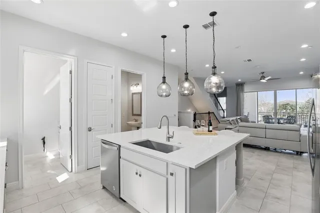 a large white kitchen with a large island