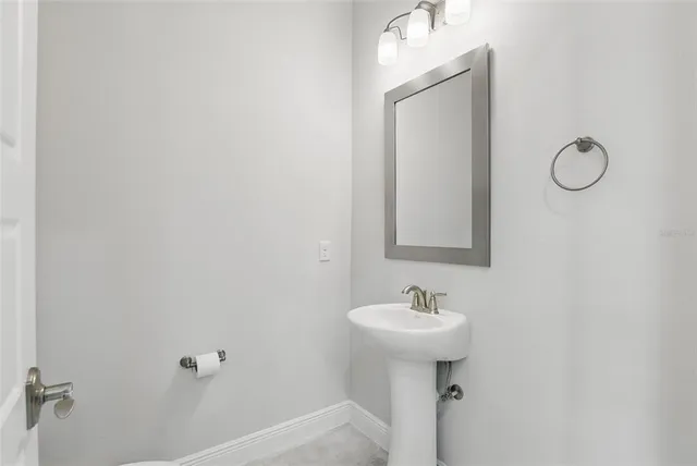 a bathroom with a sink toilet and a mirror