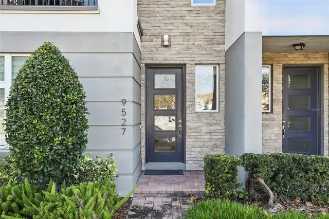 front view of a brick house with a large window and a yard