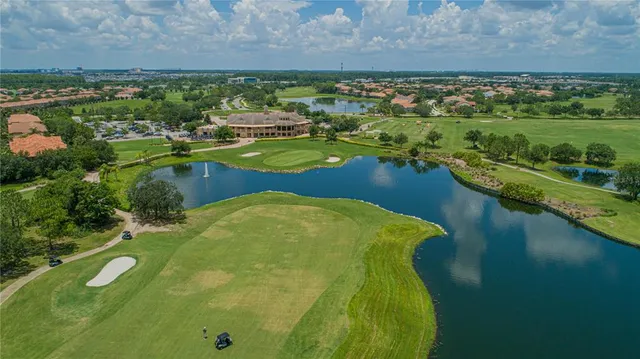 an aerial view of a residential houses with outdoor space and a lake view