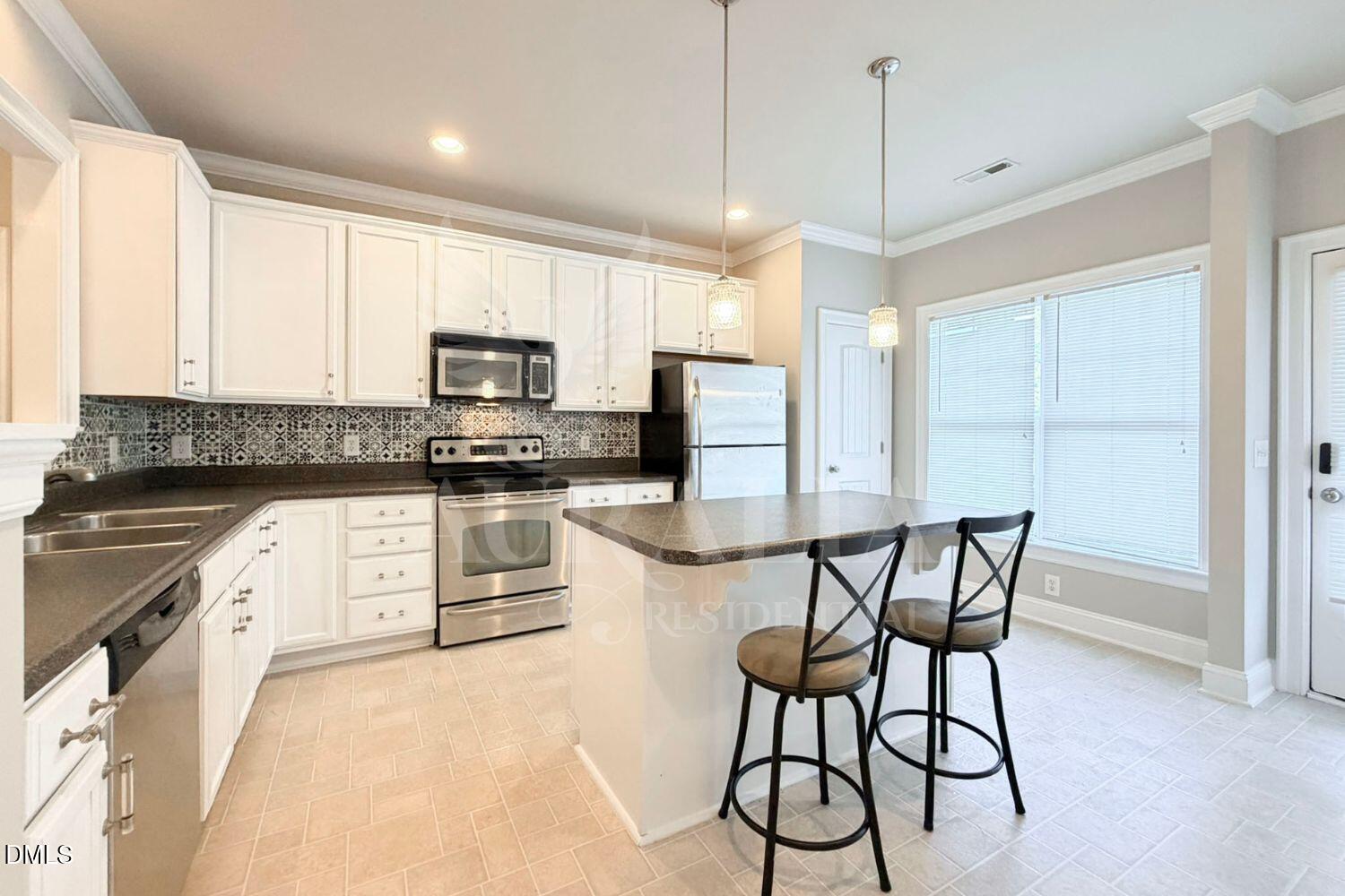 7754 ACC Boulevard Raleigh, NC 27617 - Photo 7 of 41 a kitchen with granite countertop a stove a sink and a refrigerator