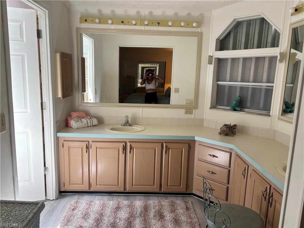 49 Turquoise Avenue, Unit 49T Naples, FL 34114 - Photo 24 of 29 a bathroom with a sink and a mirror