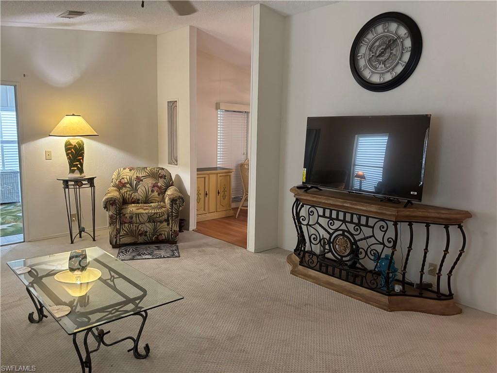 49 Turquoise Avenue, Unit 49T Naples, FL 34114 - Photo 7 of 29 a living room with furniture and a flat screen tv
