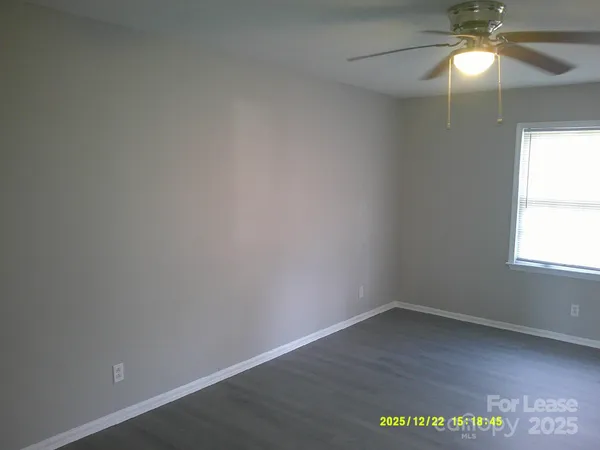en empty room with a window and wooden floor
