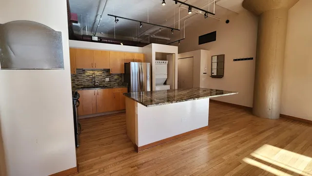 a kitchen with stainless steel appliances granite countertop a refrigerator and a stove