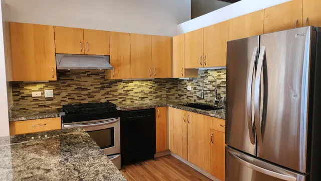a kitchen with stainless steel appliances granite countertop a refrigerator and a stove
