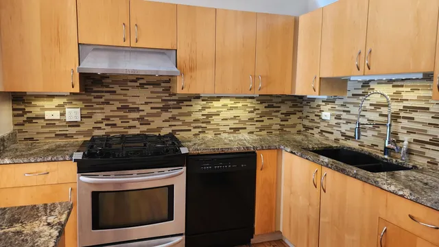 a kitchen with stainless steel appliances granite countertop a stove a sink and a microwave