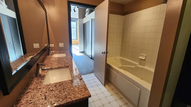 a bathroom with a tub shower and vanity