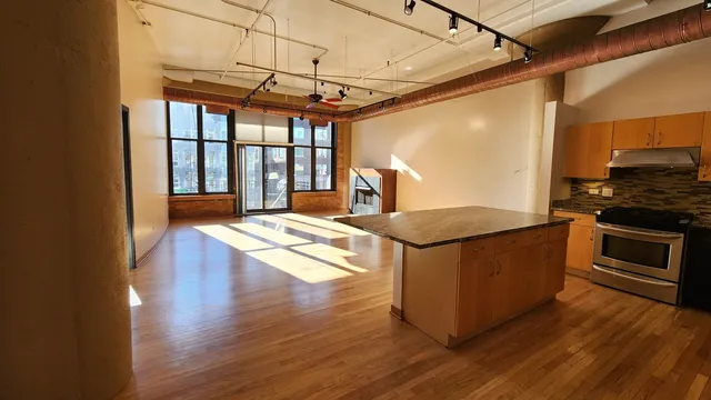 a kitchen with stainless steel appliances granite countertop a stove a refrigerator and a wooden floors