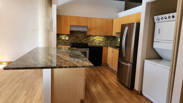 a kitchen with stainless steel appliances granite countertop a refrigerator and a stove