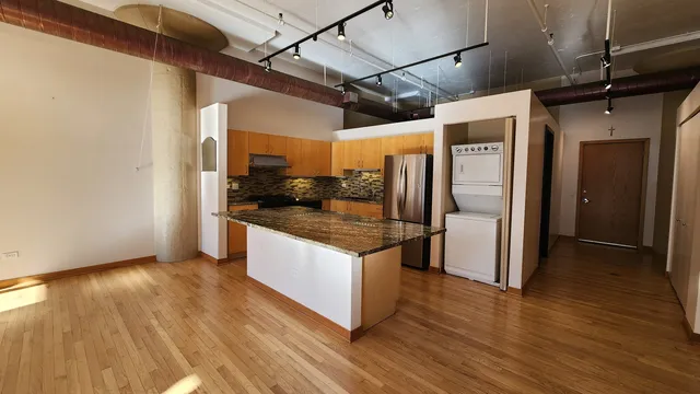 a kitchen with stainless steel appliances granite countertop a sink and a refrigerator