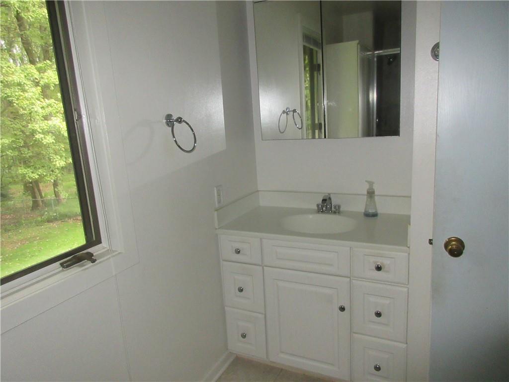 136 Hamel Road Renfrew, PA 16053 - Photo 11 of 18 a bathroom with a granite countertop sink a mirror and shower