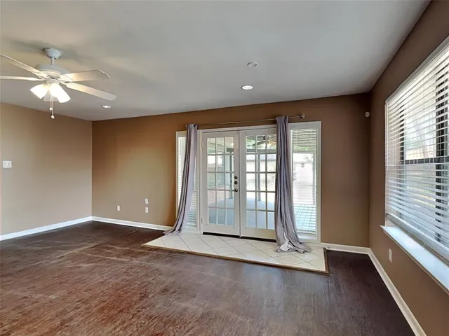 a view of an empty room with a window and wooden floor
