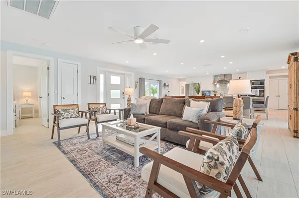 a living room with lots of furniture and view of kitchen