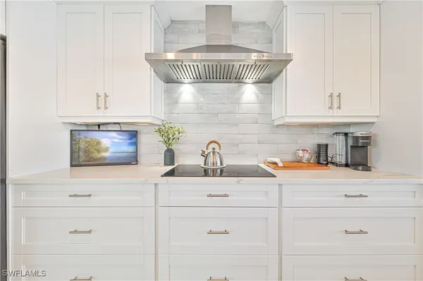 a kitchen with white cabinets and appliances