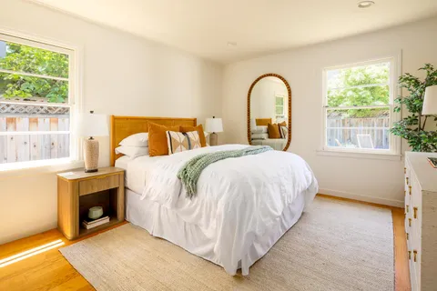 a bed sitting in a bedroom next to a window