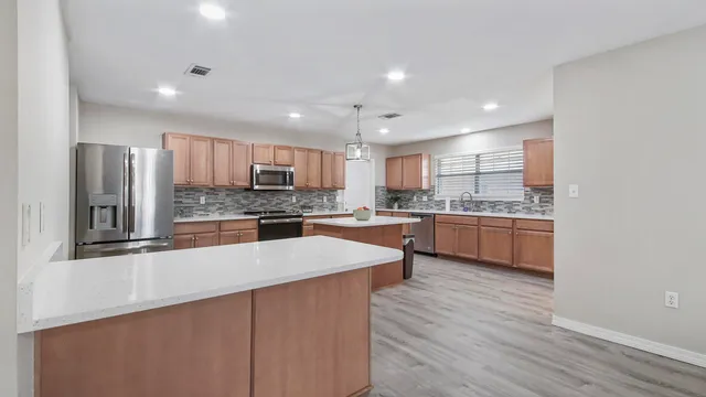 a large kitchen with stainless steel appliances and a sink