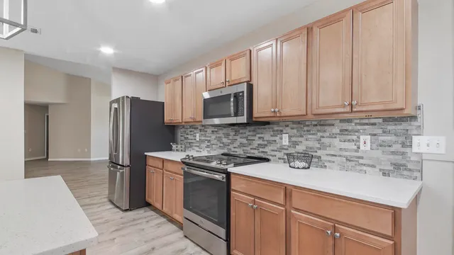 a kitchen with stainless steel appliances granite countertop a refrigerator stove and sink