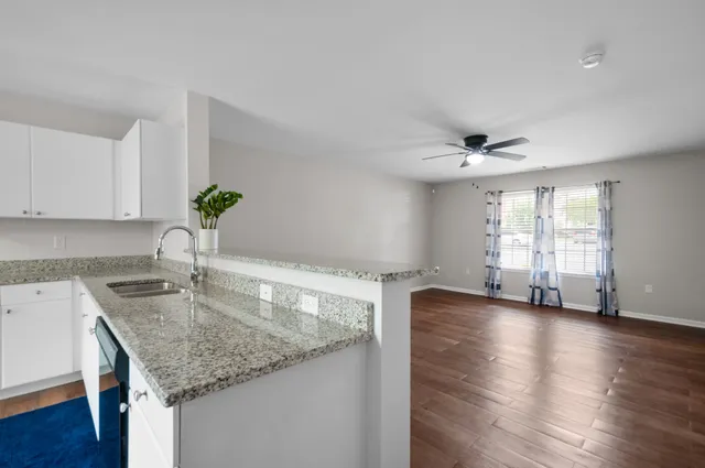 a kitchen with granite countertop a sink counter top space and cabinets
