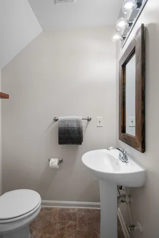 a bathroom with a sink a toilet and mirror