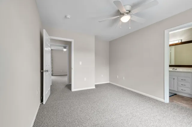 an empty room with closet and a chandelier fan