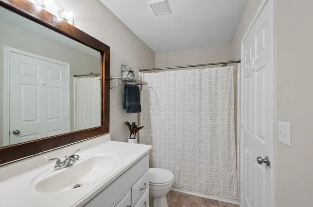a bathroom with a sink a toilet and shower curtain