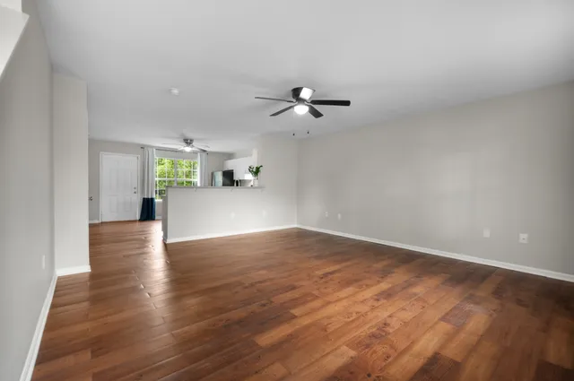 a view of a kitchen with a dishwasher a kitchen island hardwood floor and a ceiling fan
